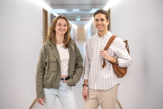 Etudiante et étudiant dans un couloir du campus